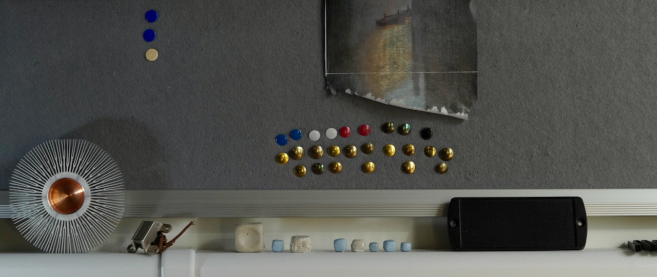 decorative image of small objects in front of a pinboard with pins